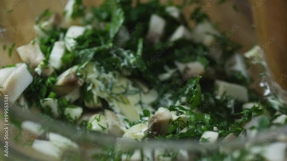 Close up of unrecognizable cook stirring fresh salad made of garlic, mushrooms and parsley Close up of unrecognizable cook stirring fresh salad made of garlic, mushrooms and parsley
