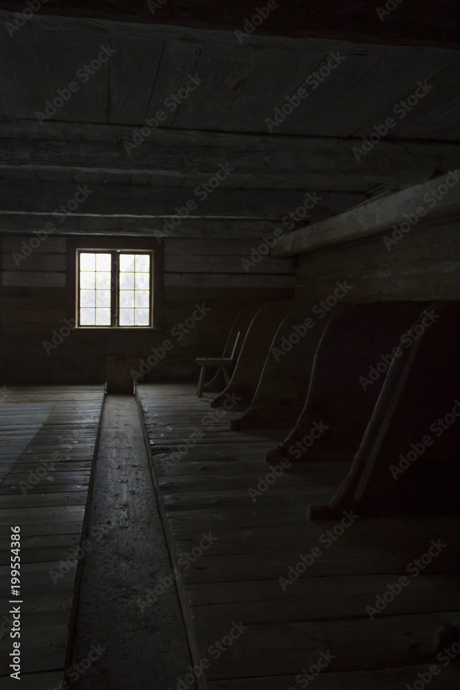 Old stable for livestock, with light coming in from a single window. Old stable for livestock, with light coming in from a single window.