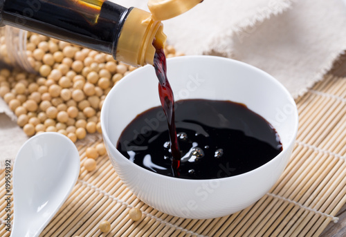 Close up of pouring soy sauce in white bowl 