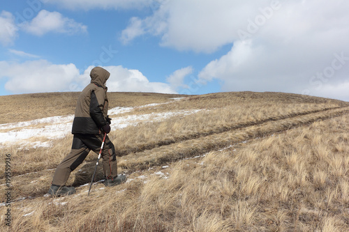 Nordic Walking -  adult man climbing to top of a mountain Bald, Bugotaksky hills, Novosibirsk region, Russia