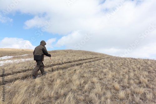 Nordic Walking - adult man climbing to top of a mountain Bald, Bugotaksky hills, Novosibirsk region, Russia