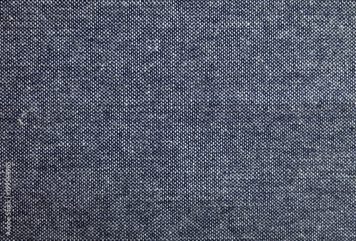 Blue and white cotton denim fabric photographed to provide a dark background