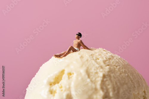 miniature man in swimsuit on an ice cream. photo