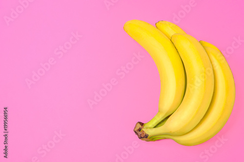 Funny concept image - bunch of bananas isolated on a pink background in top view (copy space)