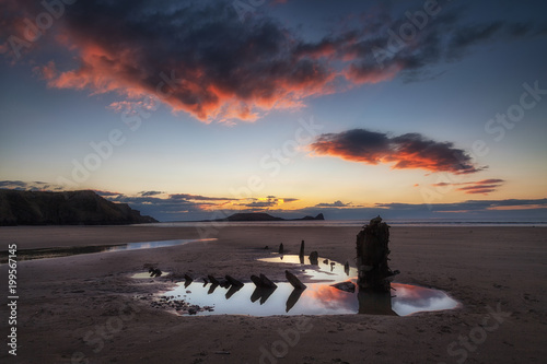 Sunset at Worms Head and the wreck of the Helvetia, at Rhossili Bay on the Gower peninsula, South Wales, UK photo