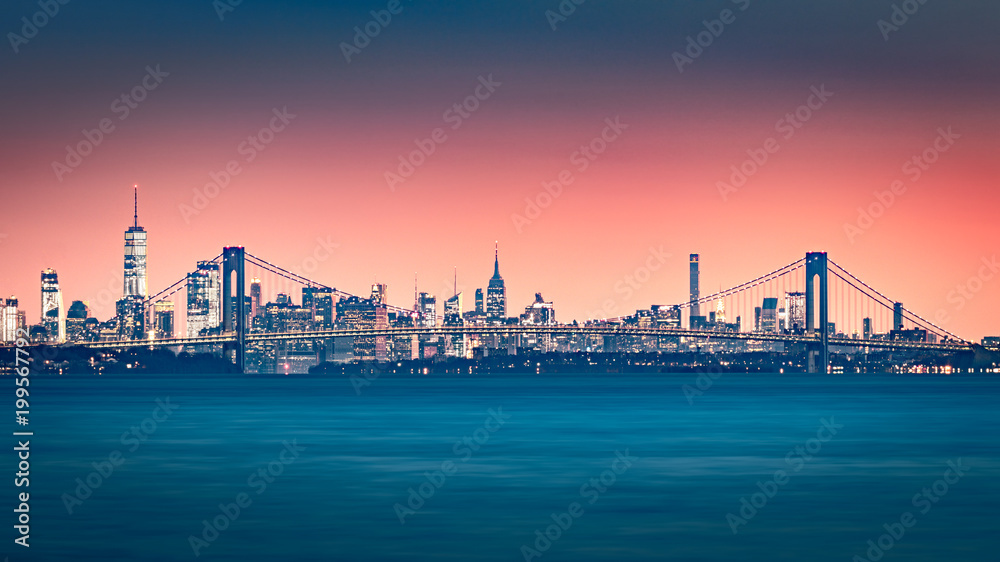 Verrazano Narrows Bridge gates the access to Upper New York Bay. Manhattan skyline rises behind the bridge. Verrazano Narrows Bridge gates the access to Upper New York Bay. Manhattan skyline rises behind the bridge.