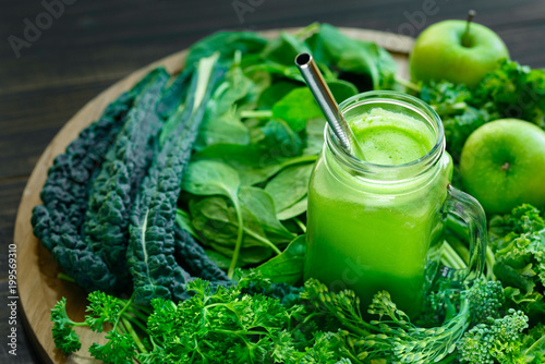 Fotografia Cancer preventing leafy greens with a glass jar of fresh juice with a sliver dri