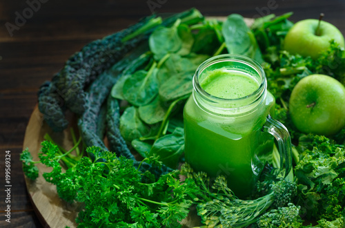 Variety of Organic Leafy Greens with a Glass Jar of Fresh Juice photo