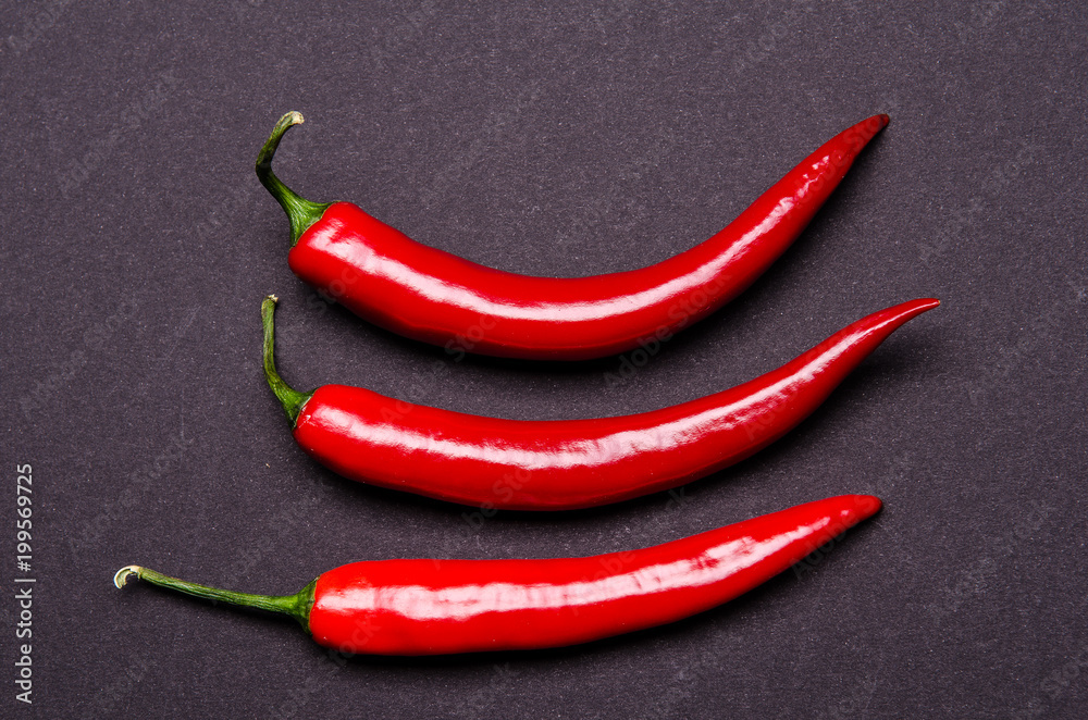 three chilies on a grey background