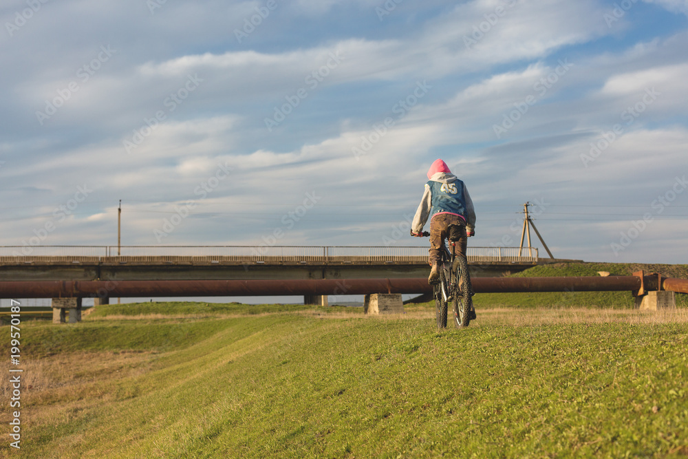 Mountain biker riding on green grass, spring bike ride Mountain biker riding on green grass, spring bike ride