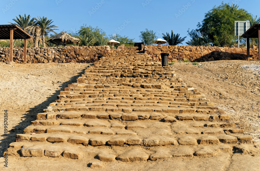 Old long staircase of roughly hewn sandstones leading to the beach of the Dead Sea in Jordan