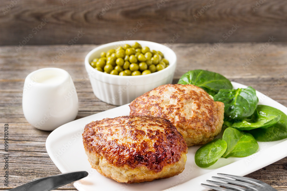 Homemade cutlets with a salad on a plate in a rustic style. Homemade cutlets with a salad on a plate in a rustic style.
