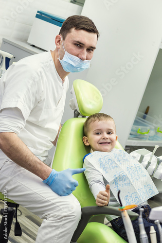 Dentist examining little boy s teeth in clinic. Dental problem.