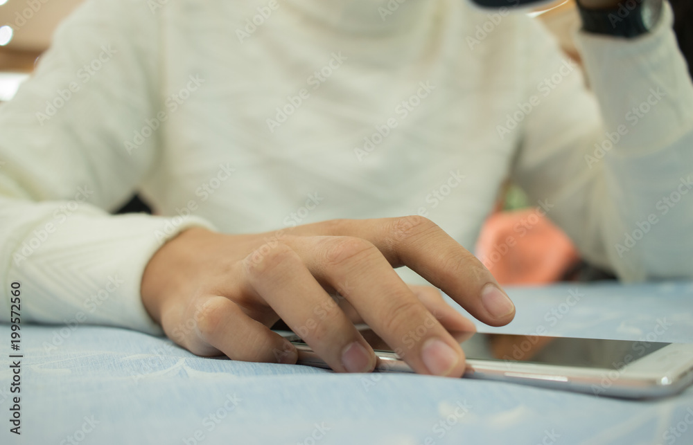 Online searching social networks by Smartphone Concept: Hand of young man pointing finger on blank screen smart phone, using hand clean gadget or typing sms message to his friends on table background Online searching social networks by Smartphone Concept: Hand of young man pointing finger on blank screen smart phone, using hand clean gadget or typing sms message to his friends on table background