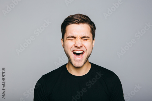 Anger, rage, shout man standing on grey background.