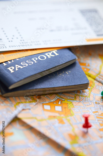 pins marking travel itinerary points on map and passport