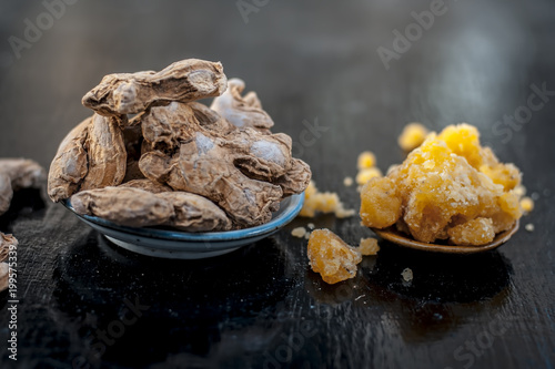 Dried ginger and jiggery a ayurvedic treatment to reduce the chances of cancer, ulcers, and diabetes its ingredients on wooden surface. photo