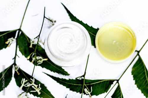 Close up of cream of Neem,Nim, Indian Iilac or Azadirachta indica with the leaves of neem tree isolated on white with benefits like it removes the black skin and acnes and pimples. photo