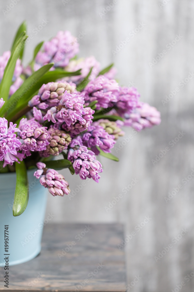 Bouquet of Beautiful violet and lilac hyacinths. Spring flowers in vase on wooden table. bulbous plant. Vertical photo