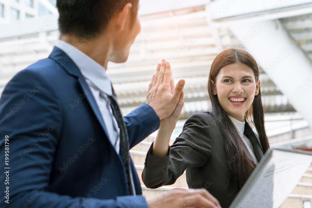 Asian colleagues team success concepts, Businessman and businesswoman looking at each other and doing fist bump celebrate after work done complete.