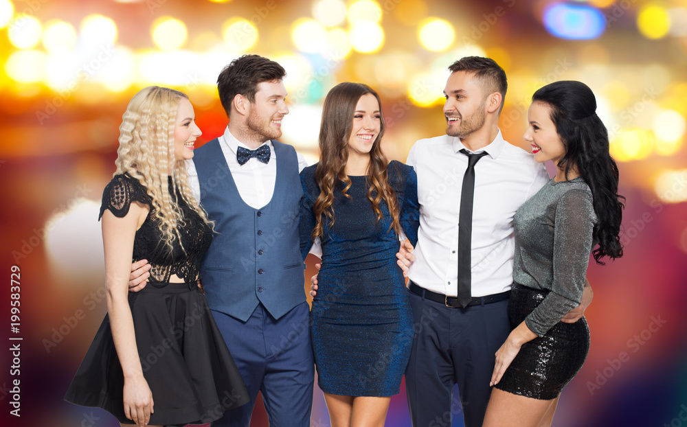 people and holiday style concept - happy friends in party clothes hugging over night city lights background