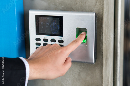 Employee scanning fingerprint record hours work time.