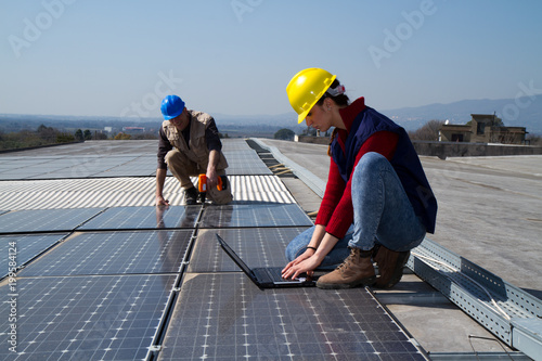 Wallpaper Mural young engineer girl and an elderly skilled worker fitting a photovoltaic plant Torontodigital.ca