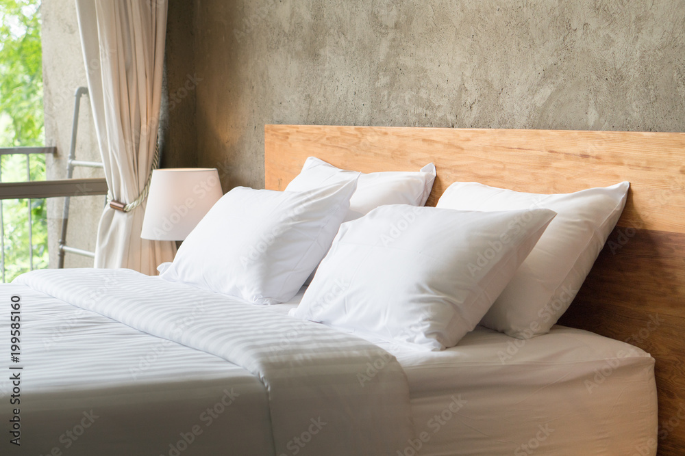 White pillows on the bed in loft style bedroom. - obrazy, fototapety, plakaty 