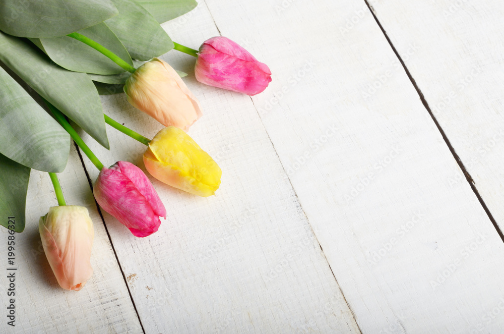 Fresh tulips on white wooden table with copy-space high angle view