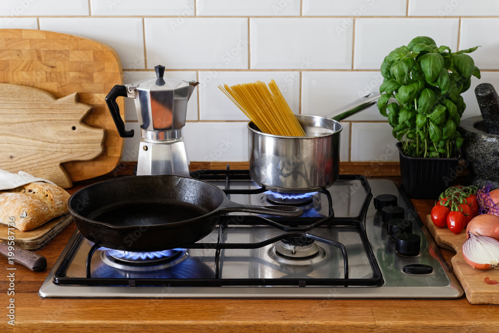 Cooking meal on a gas stove in traditional home kitchen. Wood worktop.  Stock-Foto | Adobe Stock