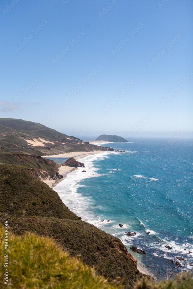 Green Rolling Hills and Waves Breaking on a Rough California Beach