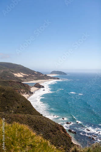 Green Rolling Hills and Waves Breaking on a Rough California Beach