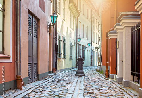 Narrow street in old city of Riga. Image slightly toned in vintage warm colors for inspiration of retro style effect
