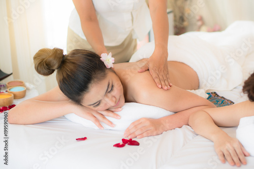 Relaxation oil massage spa salon. Beautiful young asian woman lying down on the bed relax in spa salon with massage Selective focus on hand.