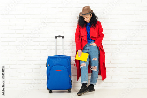 Young adorable woman in hat with suitcase ready for traveling.