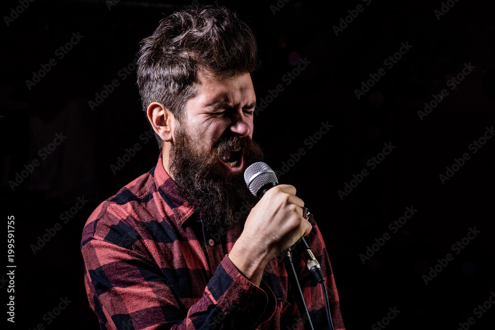 Musician with beard and mustache lighted by spotlight. Musician with beard and mustache lighted by spotlight.