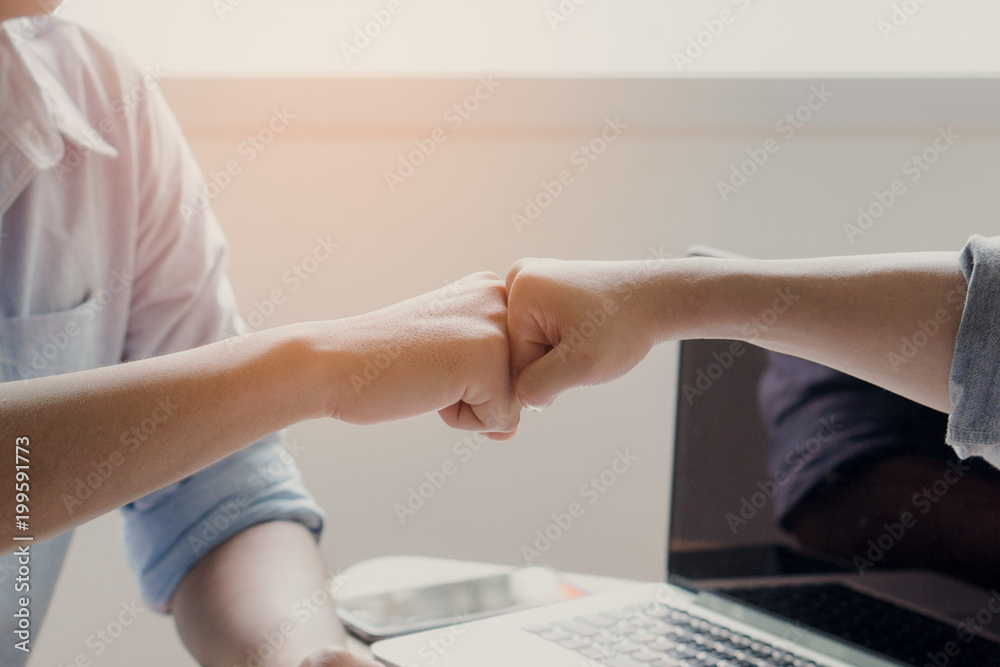 Fototapeta premium Team partner celebrating success collaboration. Two young business start up doing fists bump celebration business project plan successfull ready to start.