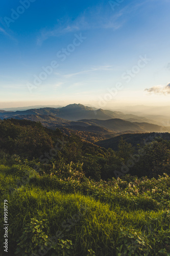 Smoky mountain landscape with mountain and light rays before sunset. © Korradol