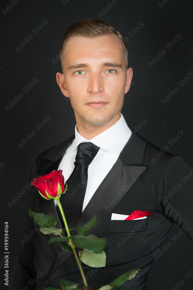 Handsome businessman hold flower over gray background Handsome businessman hold flower over gray background