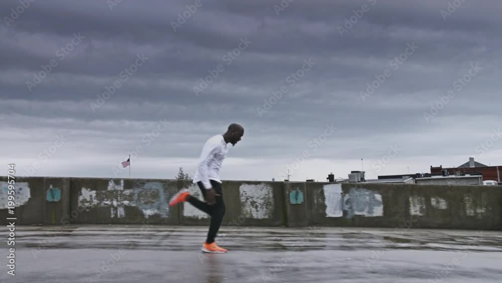 4K Man sprinting on wet concrete