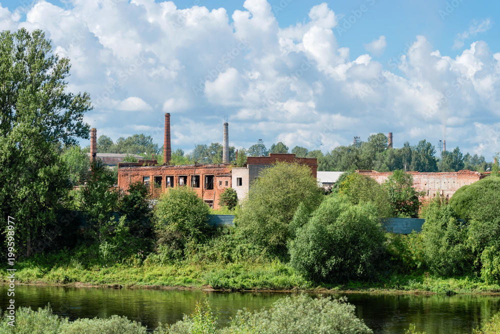 Old ruined factory building on the banks of the river
