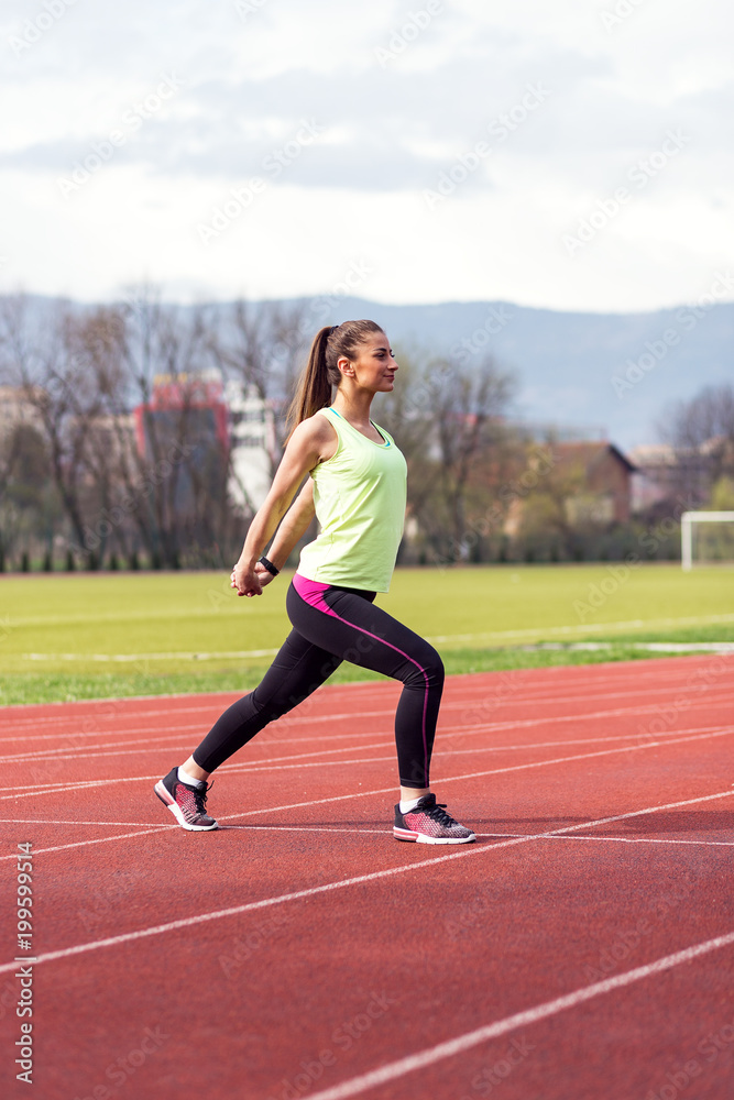 Sporty woman doing exercise at stadium