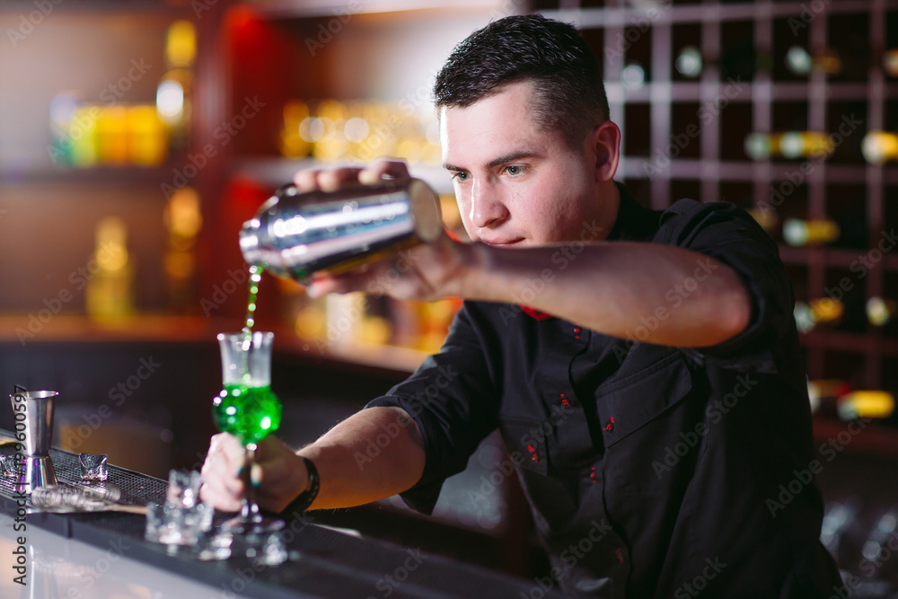 Bartender pouring fresh cocktail in fancy glass
