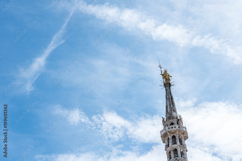 The Golden Madonnina on the top of Milan Duomo or cathedral, Italy. The Golden Madonnina on the top of Milan Duomo or cathedral, Italy.