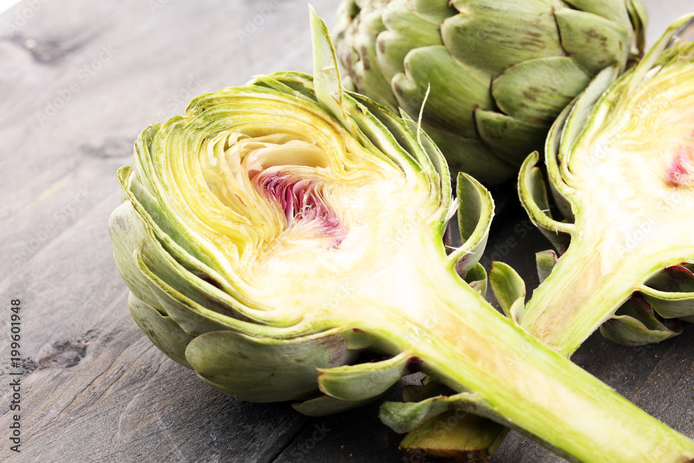 Obraz premium artichokes on grey background. fresh organic artichoke flower.