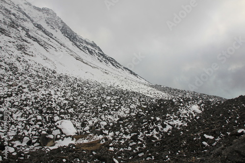 Scene on the way down from Tserko Ri, mountain and popular viewpoint in Kyanjing Gumba, Langtang National Park, Nepal. Fogy spring day. Snow covered rocks. photo