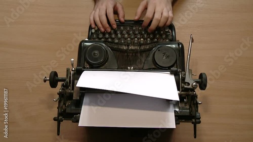 Writer typing with retro writing machine. View from above.