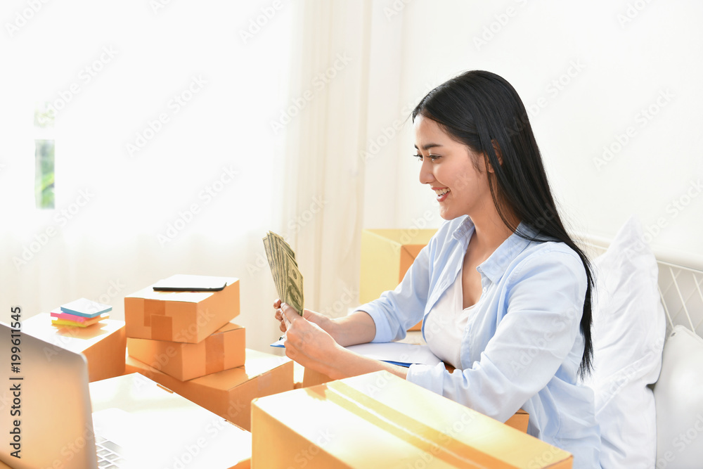 Sme business concept. Young people are packing their packages.Delivery business Small and Medium Enterprise (SMEs). Young Owner Start up for Business Online. Beautiful girls are counting money. Sme business concept. Young people are packing their packages.Delivery business Small and Medium Enterprise (SMEs). Young Owner Start up for Business Online. Beautiful girls are counting money.