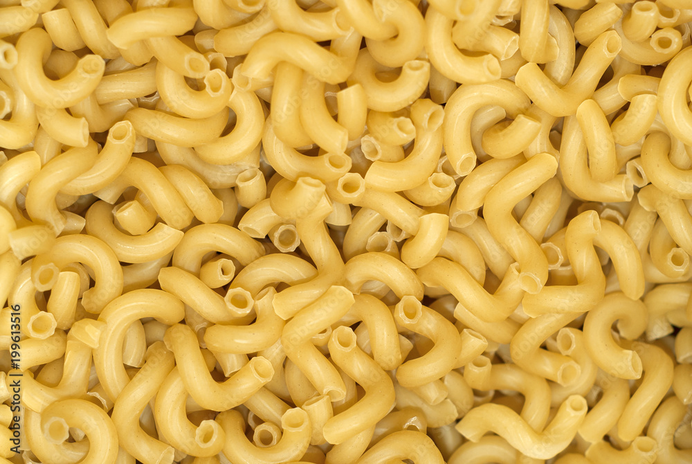 background - a pile of light yellow dry pasta on weight without packaging.. background - a pile of light yellow dry pasta on weight without packaging..