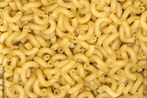 background - a pile of light yellow dry pasta on weight without packaging.. photo